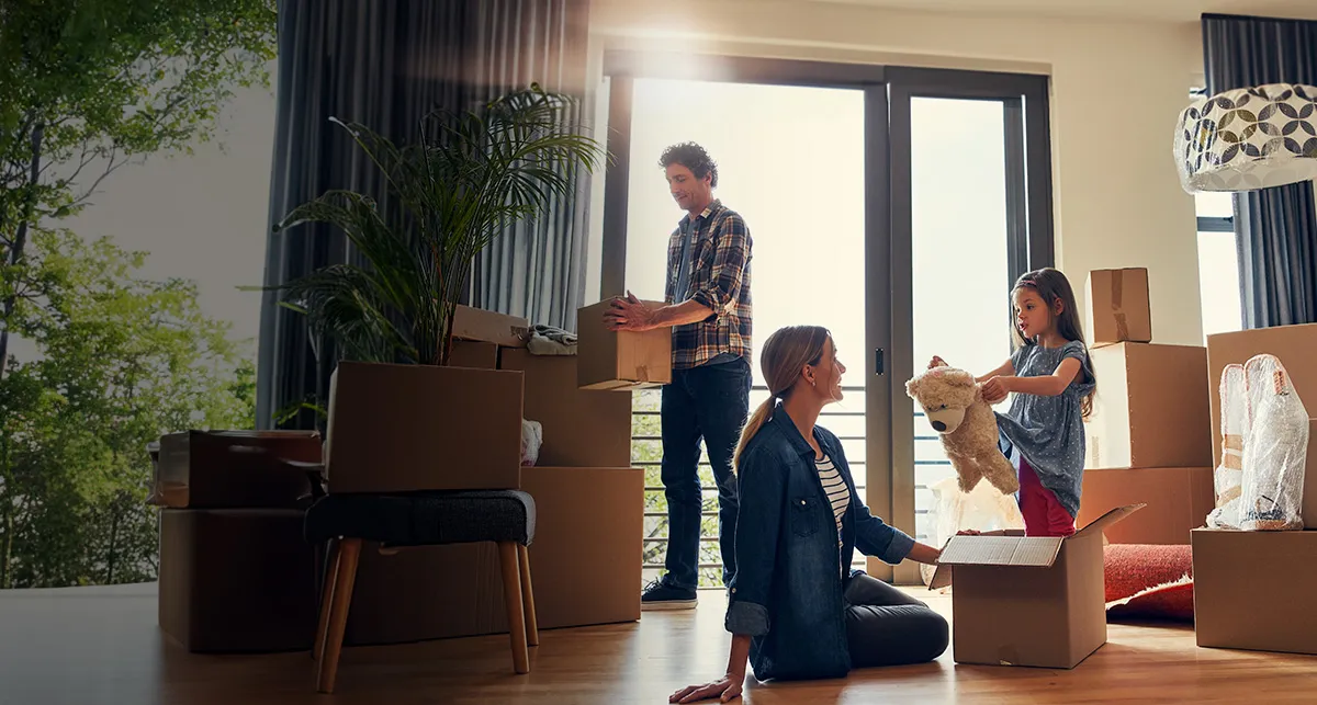 Familia colocando cajas de mudanza en su nueva casa
